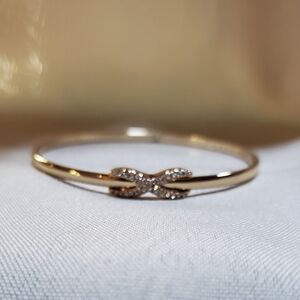 Anne Klein figure eight gold tone bangle with crystals.